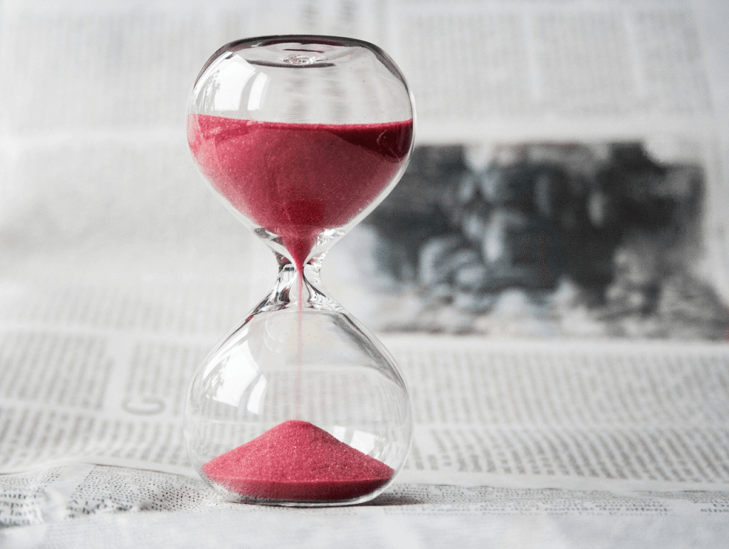 An hourglass filled with red sand, showing how flexible work policies can impact both employees and employers.