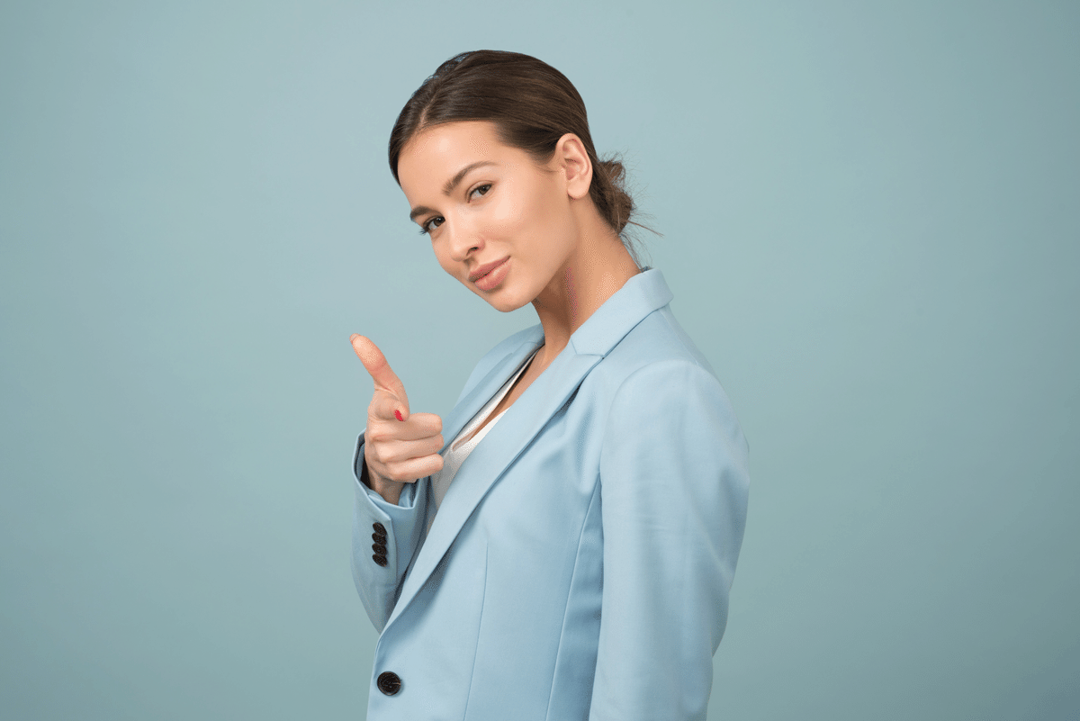 A confident great woman leader in a blue business suit against a blue background.