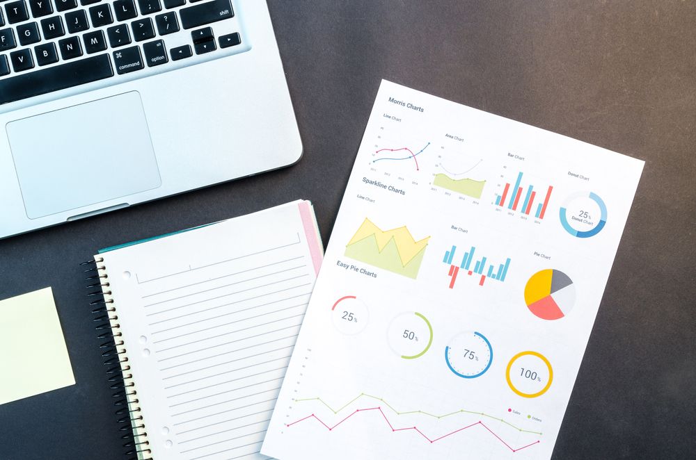 A desktop with a laptop, notes, and charts, demonstrating the many factors to consider when your nonprofit is facing inflation