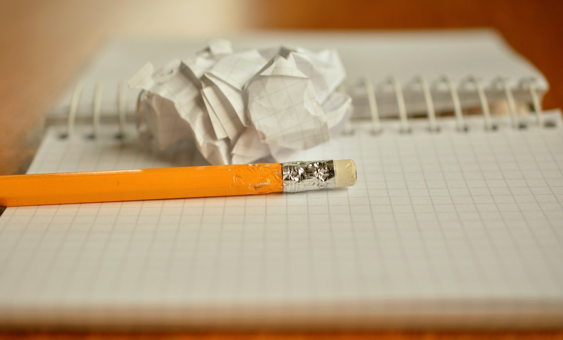 A pencil and a crumpled piece of notebook paper, representing three toxic leadership habits we should relegate to the dustbin.