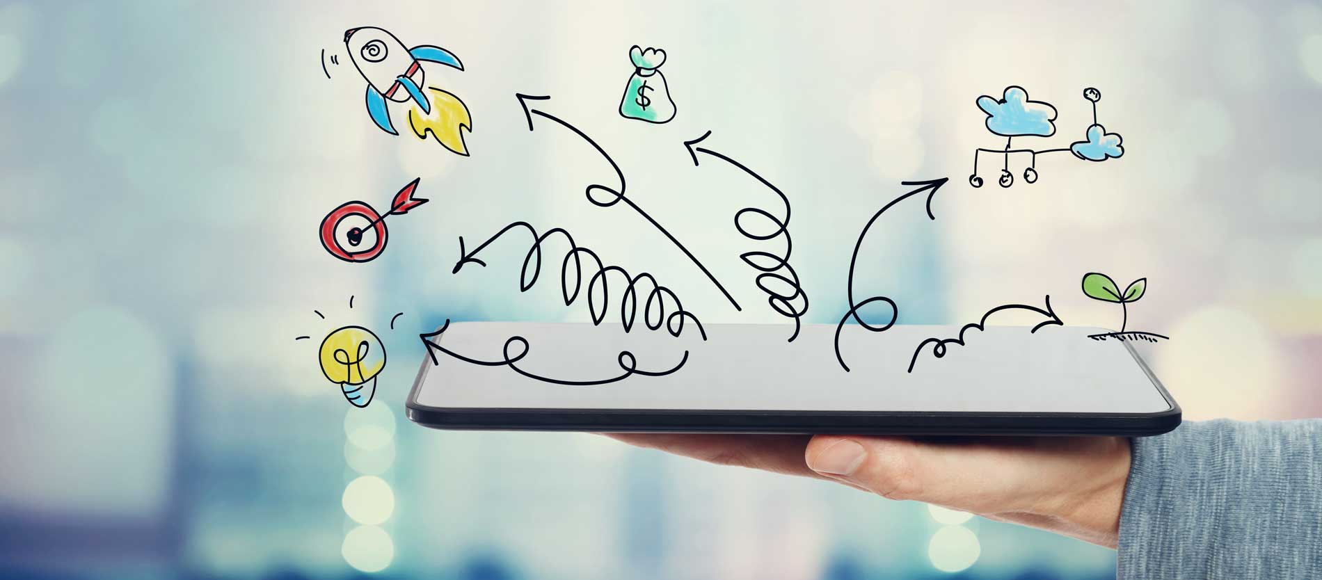 A picture of a hand holding a tablet with hand-drawn images drawn like doodles jumping off of it. Showing how vision and mission statements inspire strategic plans.