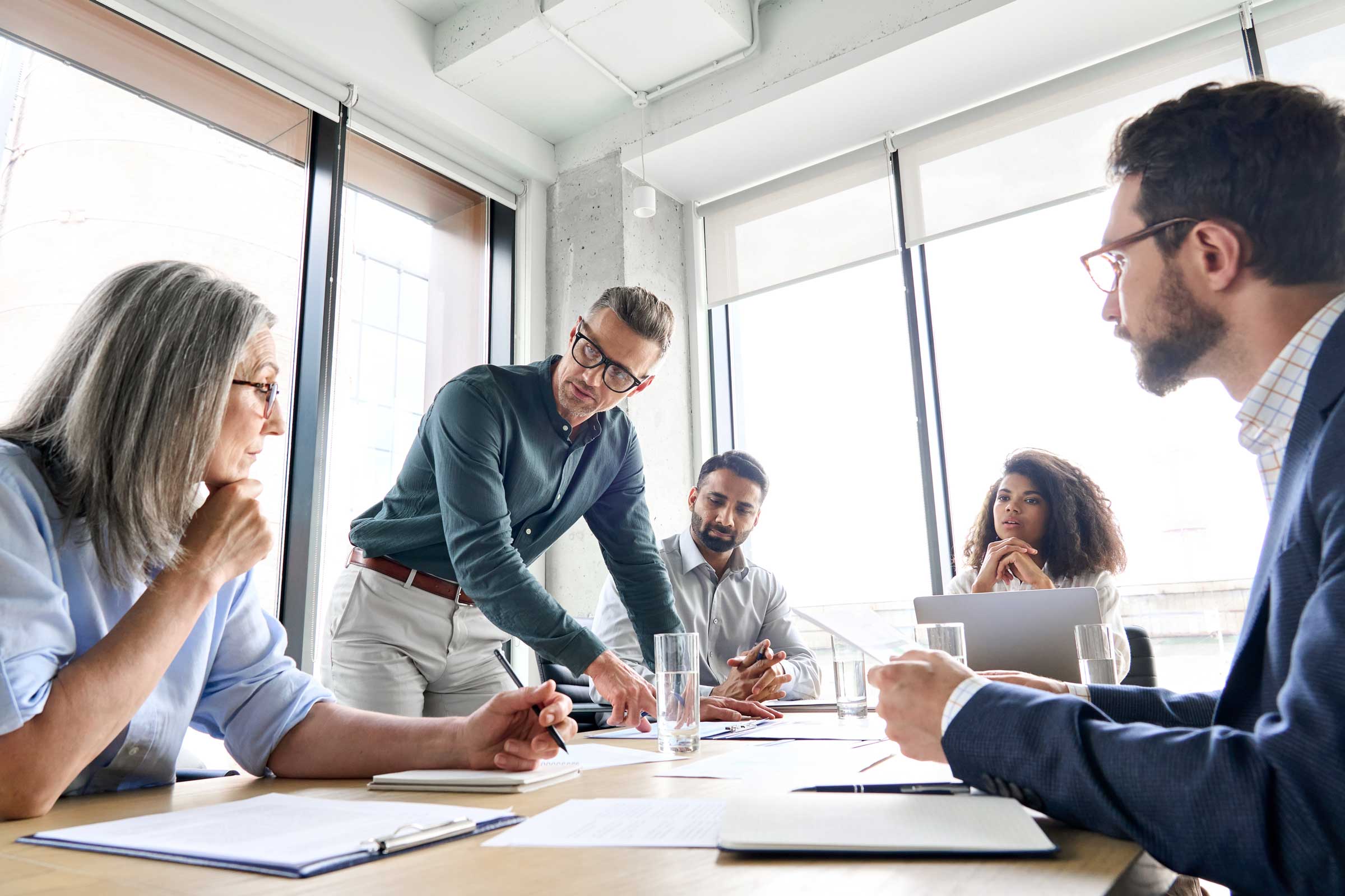 A group of staff and board members in a conference room brainstorming, showing why creative thinking is important in strategic planning.